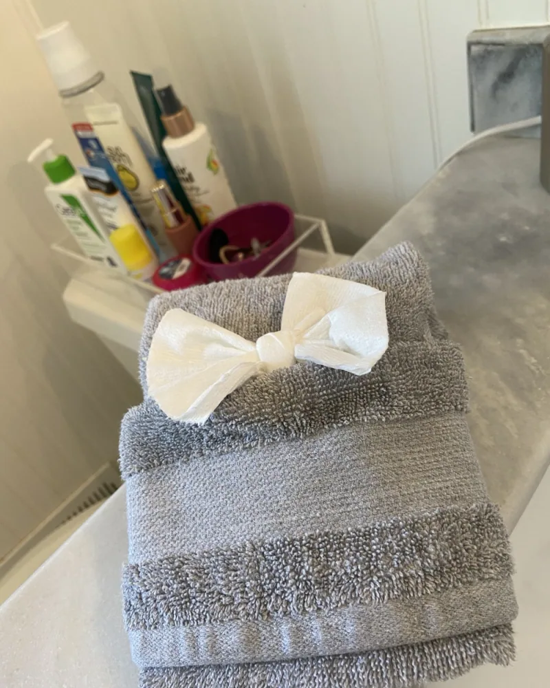 Folded towels finished with a bow — our signature touch